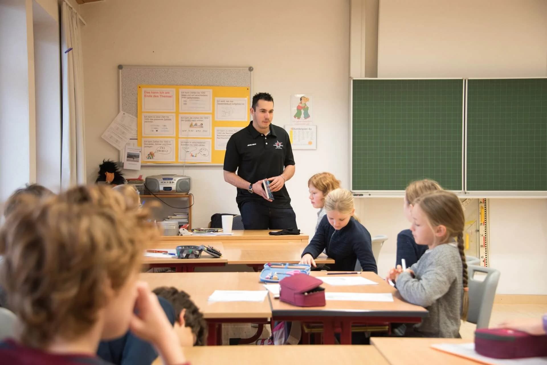 Starbulls Spieler lesen Grundschülern vor